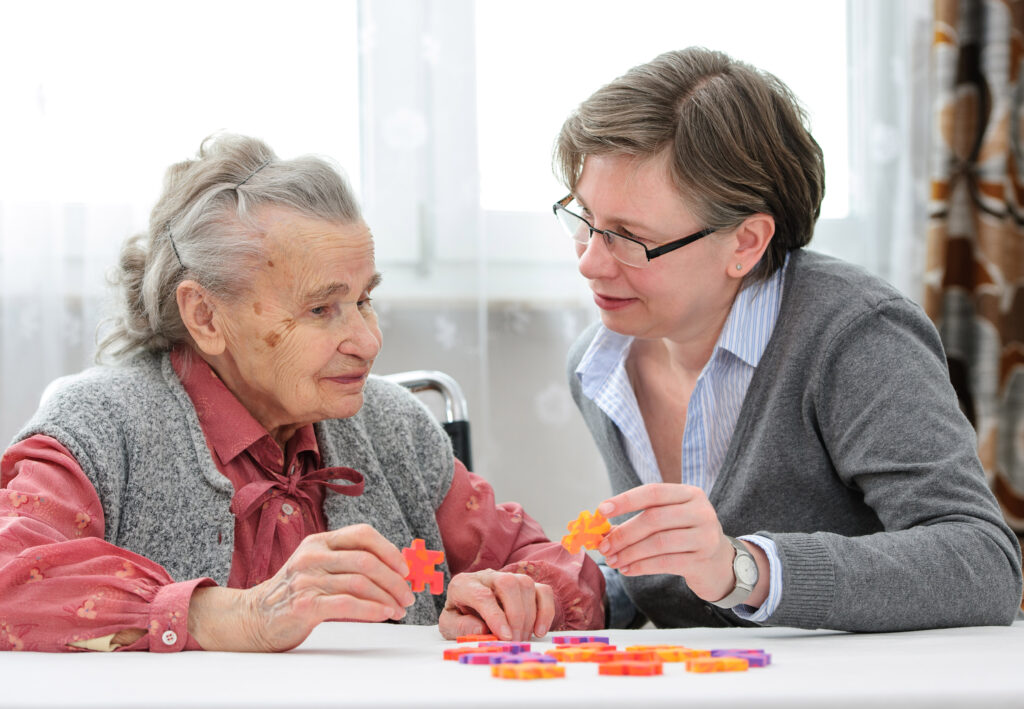 Spielen mit einer älteren Dame – Alltagshilfen des Bielefelder Sozialfonds
