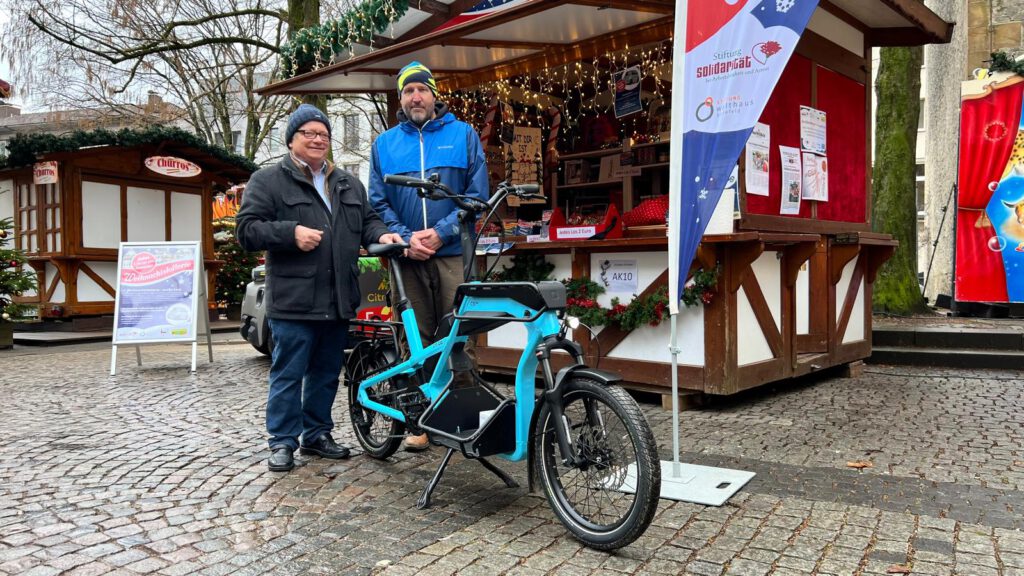 Franz Schaible (Stiftung Solidarität), Jens Neugebauer (Hauptgewinner E-Lasten-Bike)) und Martina Kellner (Stiftung Solidarität und Organisatorin Weihnachtslotterie)